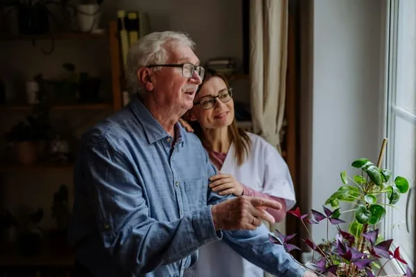 Older person and carer enjoying a peaceful moment by the window