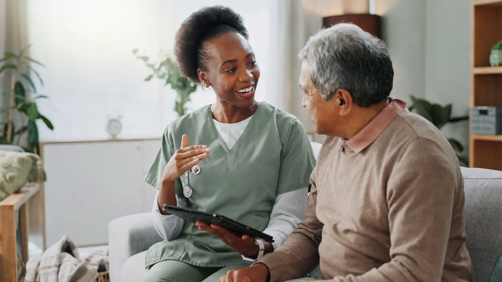 Carer discussing a care plan with an older man at home